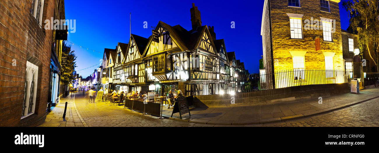 Una vista panorámica de gente comiendo y bebiendo fuera de la vieja casa de tejedores en la calle alta en Canterbury. Foto de stock