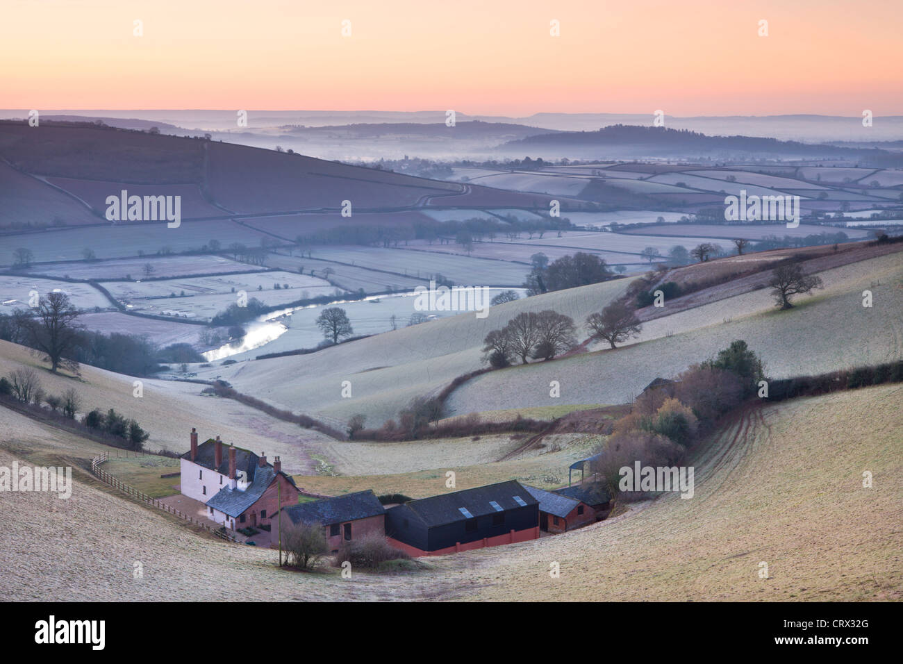 Paisaje recubierto de escarcha y edificios agrícolas al amanecer, Exe Valley, Devon, Inglaterra. Invierno (marzo de 2010). Foto de stock