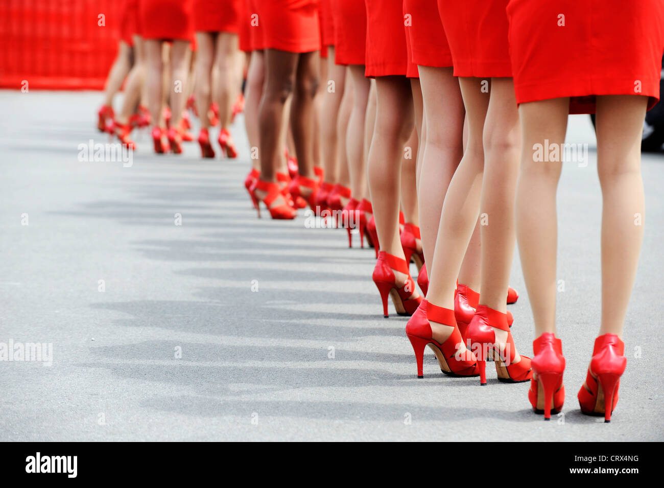 Las mujeres vestidas con trajes de color rojo y rojo zapatos de tacón de  pie en una fila Fotografía de stock - Alamy