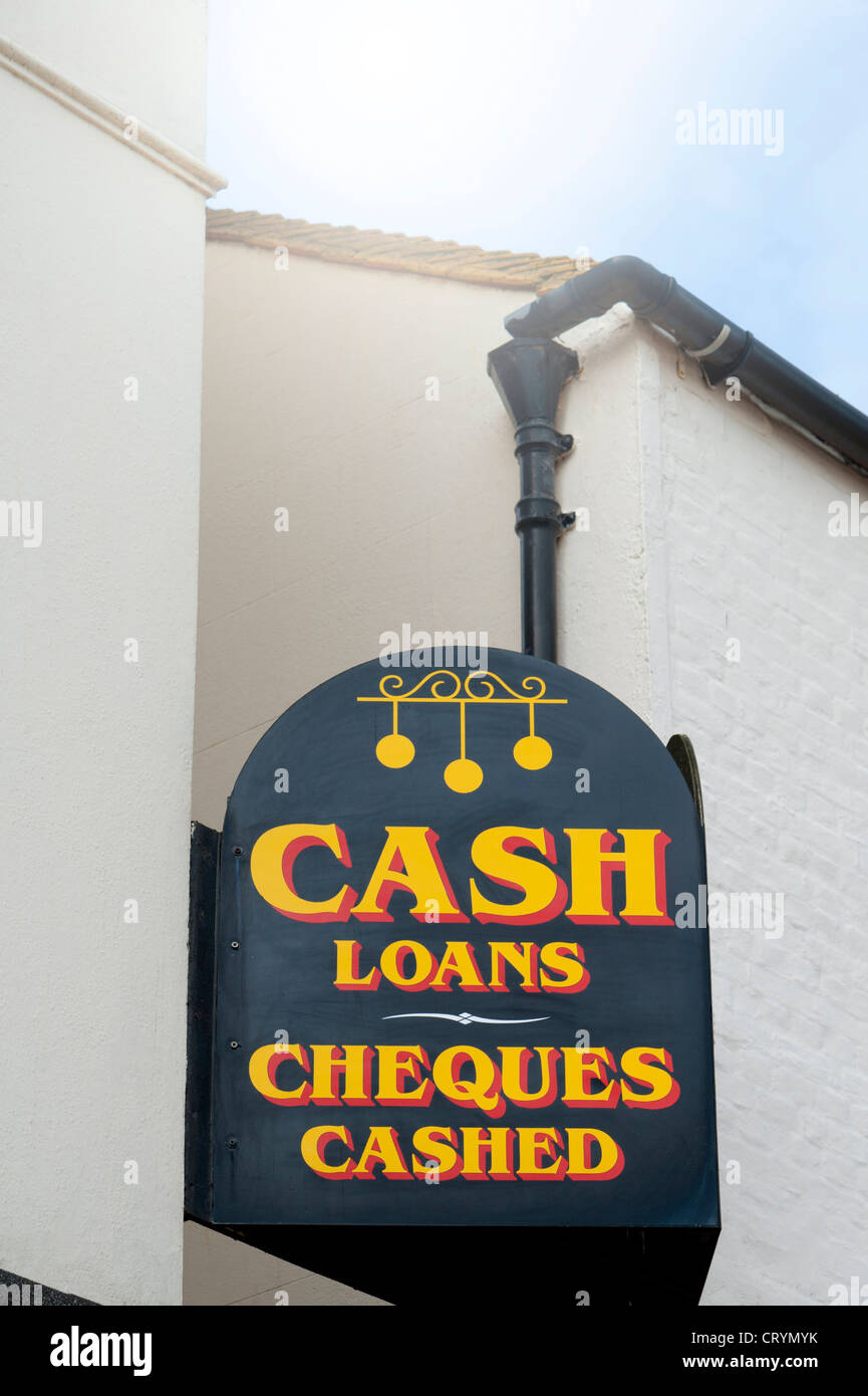 Signo del intermediario de peón en lo alto de un edificio que ofrece préstamos en efectivo y un servicio para cobrar cheques en el Reino Unido. Foto de stock