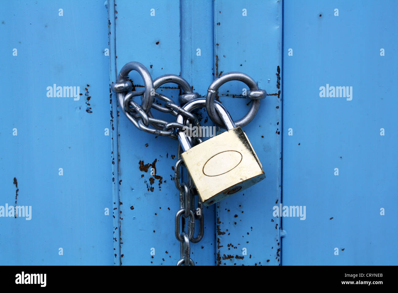 Candado con cadena en la puerta de metal azul Foto de stock