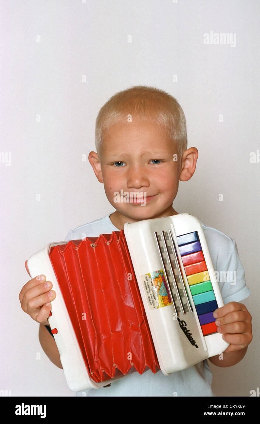 Fuenfjaehriger niño juega en su acordeón Foto de stock