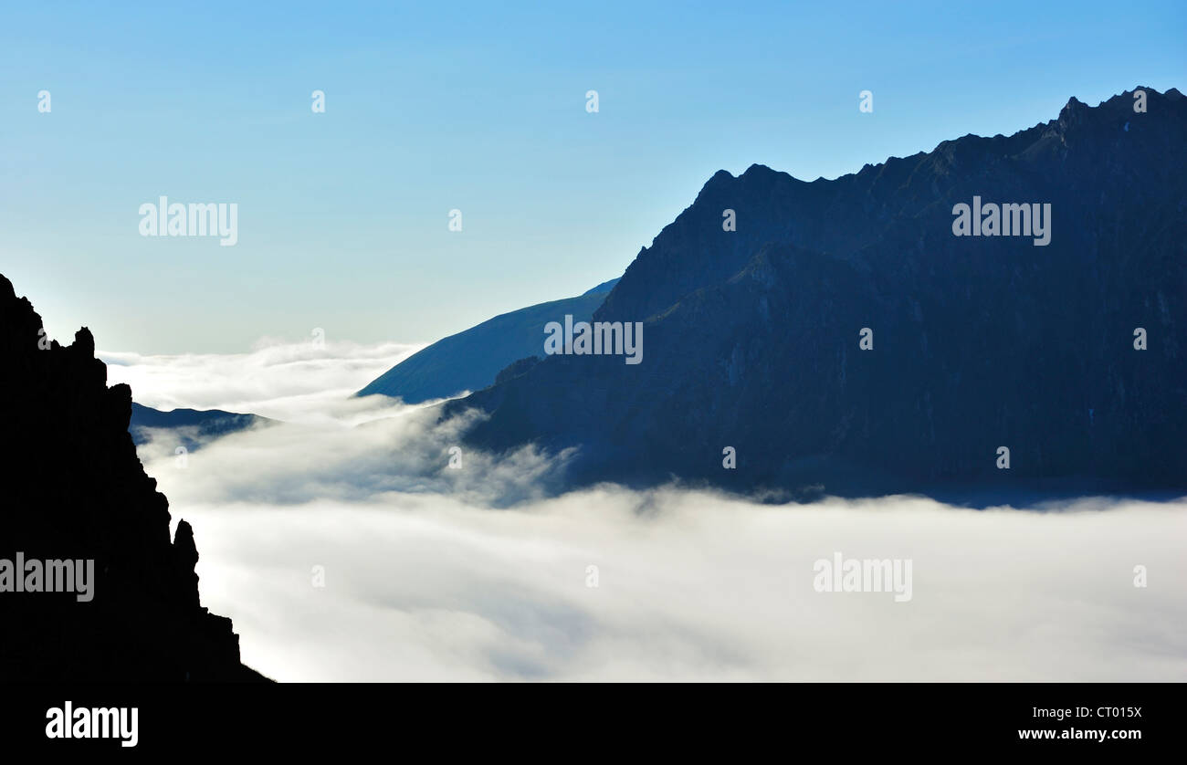 Ver más jagged edge de roca y montañas cubiertas de neblina al amanecer, el Col du Tourmalet, Hautes Pyrénées, Pirineos, Francia Foto de stock