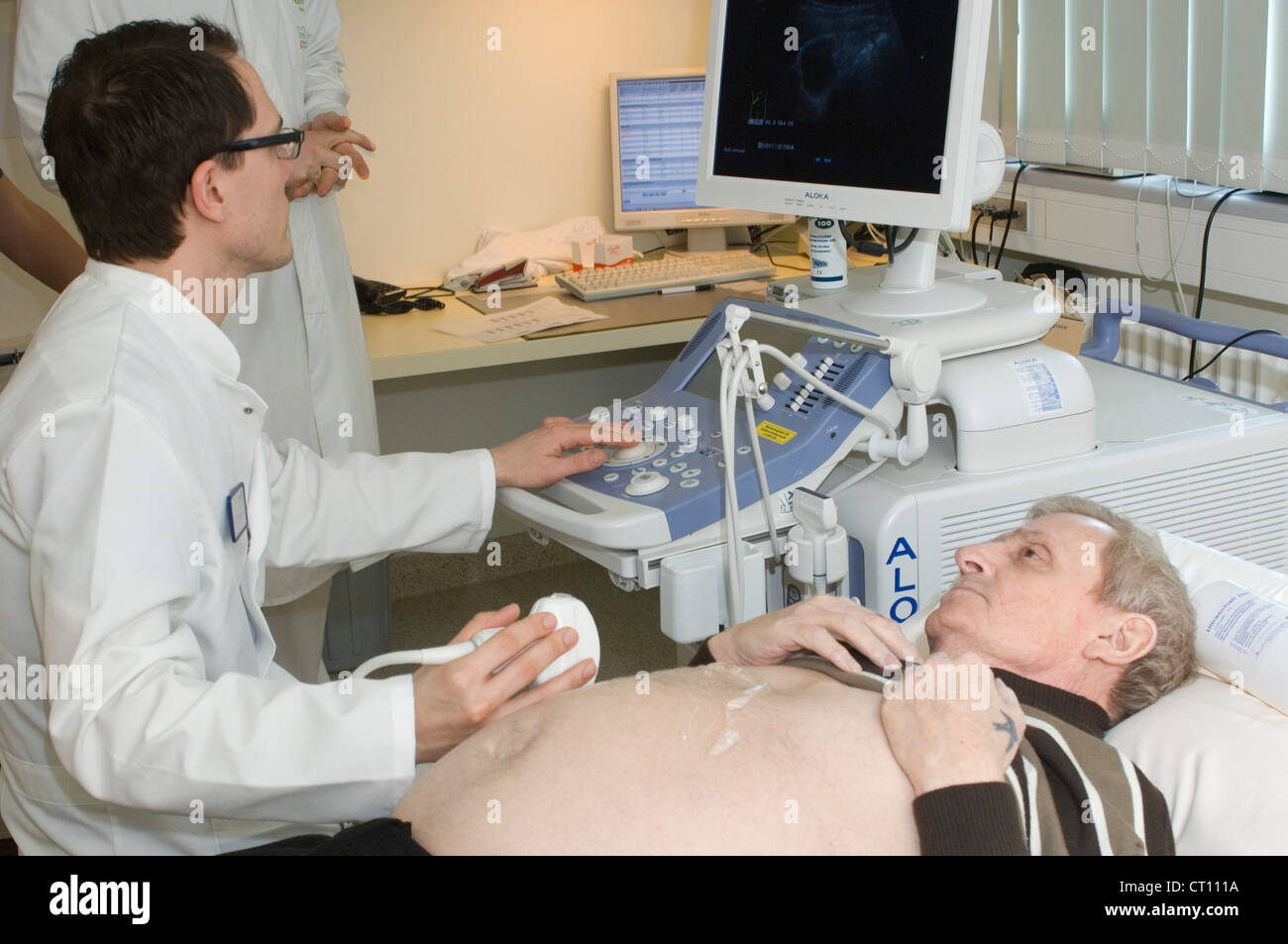Un hombre que está pasando por un procedimiento para detectar una sospecha de hernia. Foto de stock