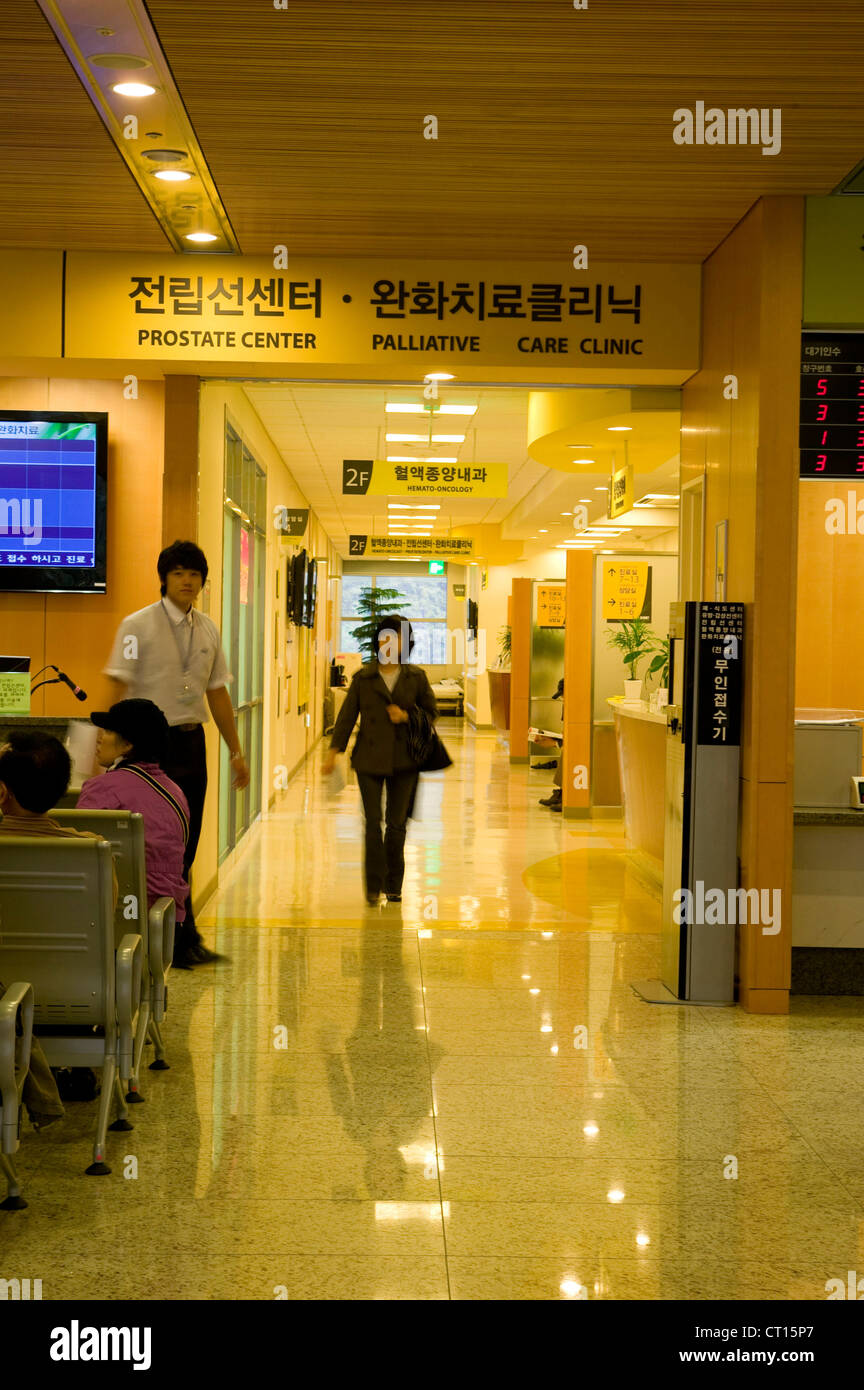Un paciente camina a lo largo de un pasillo, tras una consulta. Foto de stock