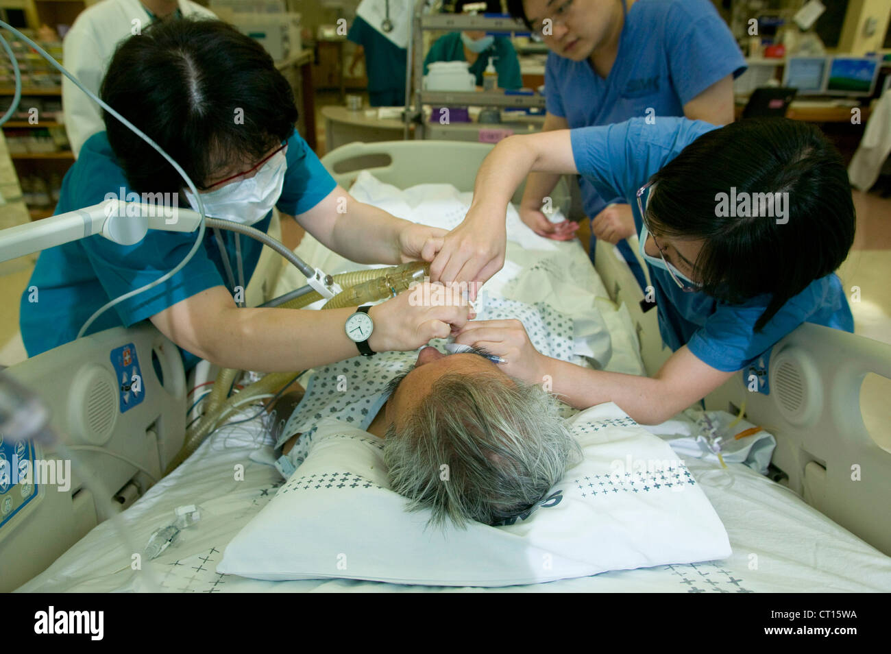 Los anestesistas administran anestesia general gas a un paciente en la unidad de cuidados intensivos. Foto de stock