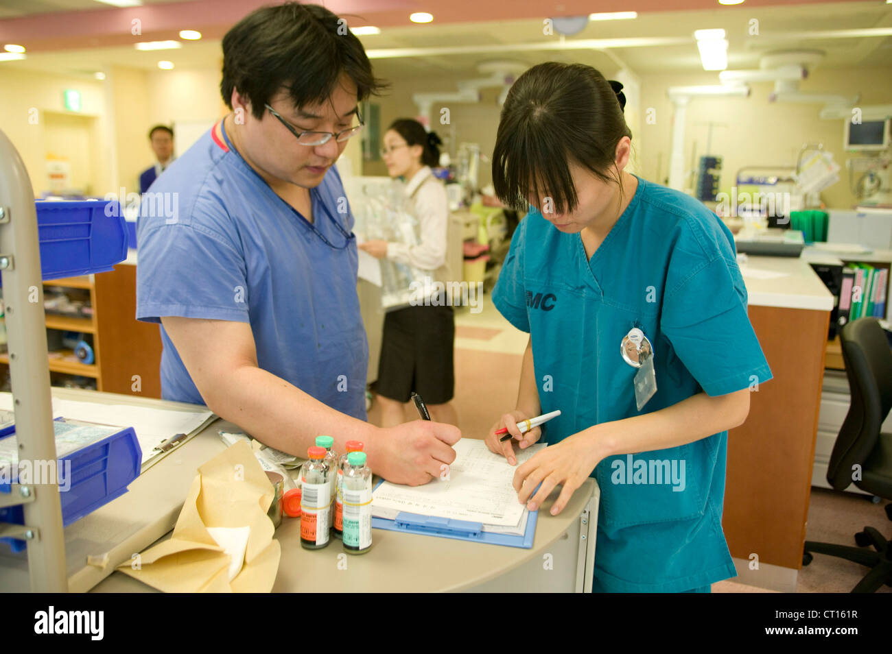Un médico y una enfermera tome tiempo para ordenar los equipos necesarios en la unidad de cuidados intensivos. Foto de stock