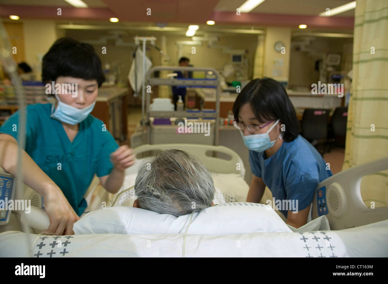 Personal médico atender a un paciente en la unidad de cuidados intensivos, Samsung Medical Center; Corea del Sur. Foto de stock