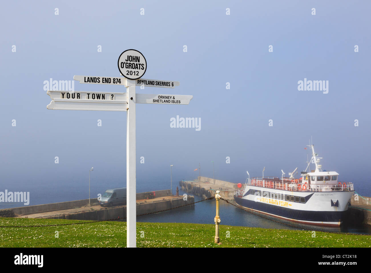 Escena con signpost y ferry con mar de bruma en la costa nororiental de John O' Groats Caithness Scotland Reino Unido de Gran Bretaña. Foto de stock