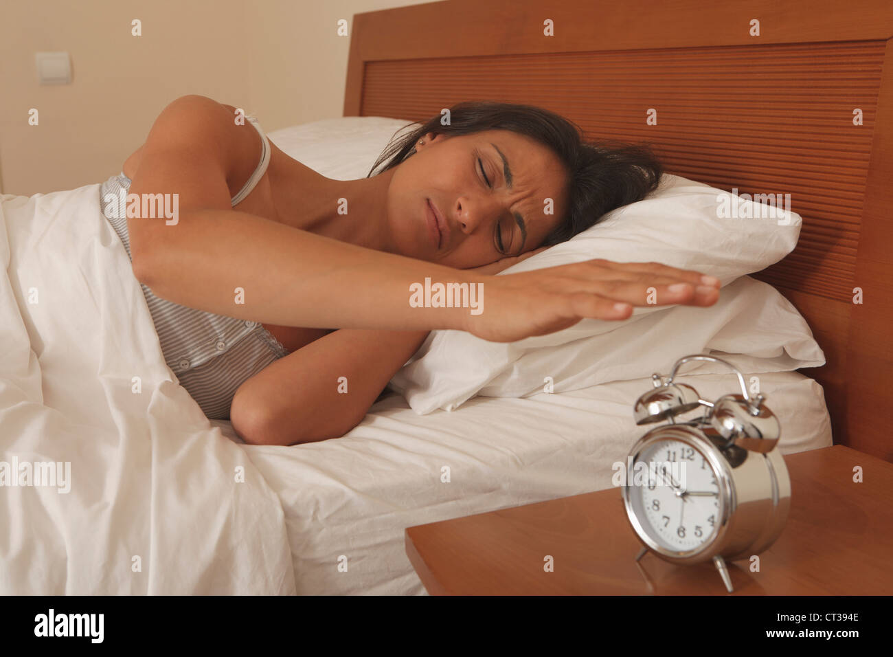 Mujer de apagar el despertador Foto de stock