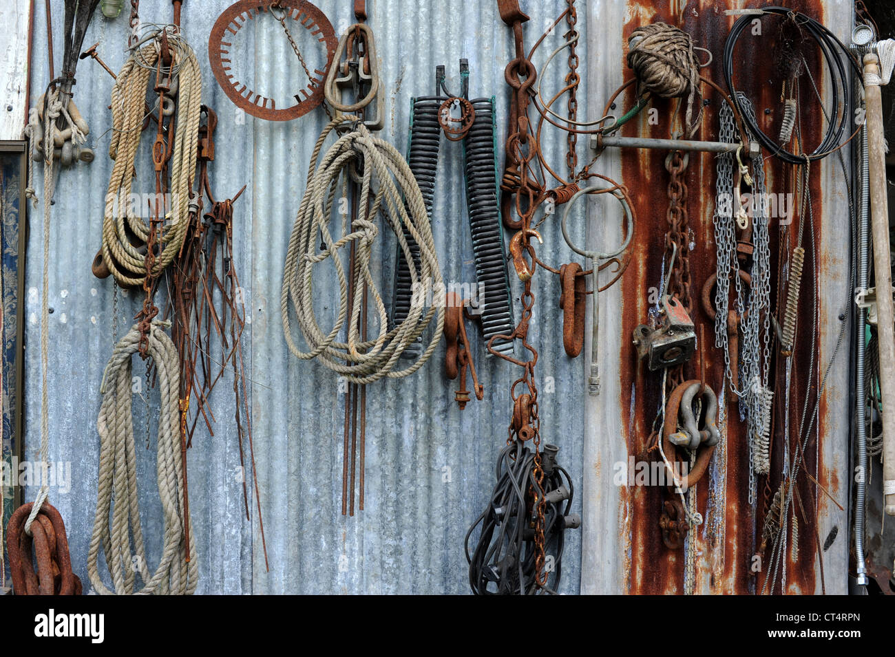 Una colección de los siglos xix y xx basura industrial se cuelga en una pared de hierro corrugado. Foto de stock