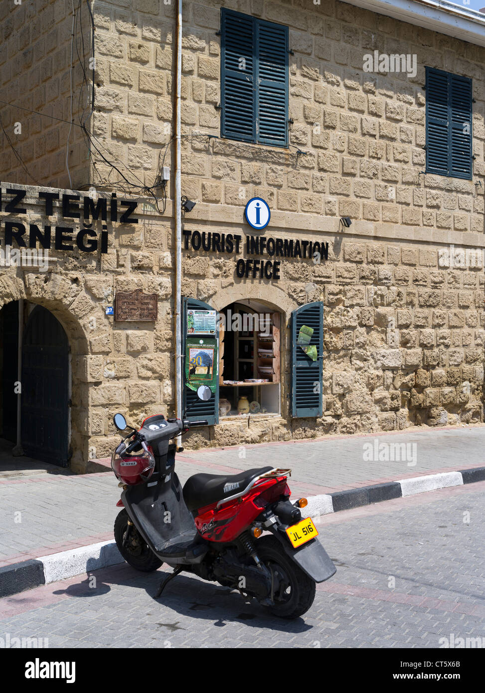 Dh Girne Harbour KYRENIA Chipre septentrional puerto antiguo edificio de oficinas de información turística y scooter Foto de stock