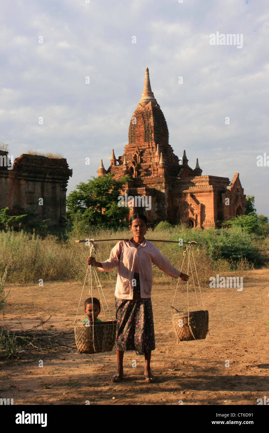 Mujer birmana local transportaba niños en canasta, Zona Arqueológica de Bagan, Mandalay, Myanmar, Región Sudeste de Asia Foto de stock