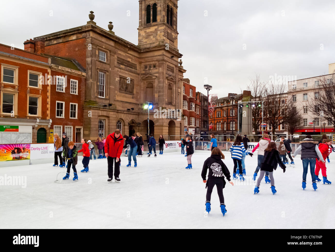 Patinar sobre hielo en el centro de la ciudad de Derby Derbyshire, Inglaterra, donde una pista de hielo temporal está instalado cada invierno en Navidad Foto de stock
