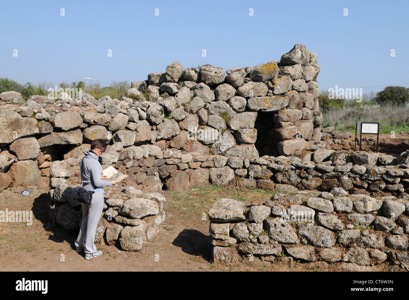 Un turista mira las ruinas del Nuraghe Losa, Cerdeña, Italia Foto de stock
