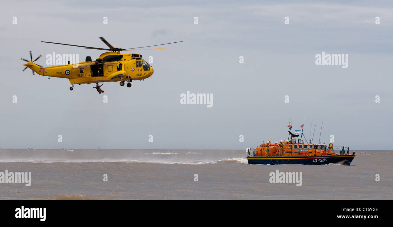 RAF SAR Sea King realizar un ejercicio de salvamento de off-shore con salvavidas RNLI clase Tyne en Lowestoft Airshow 2012 Foto de stock