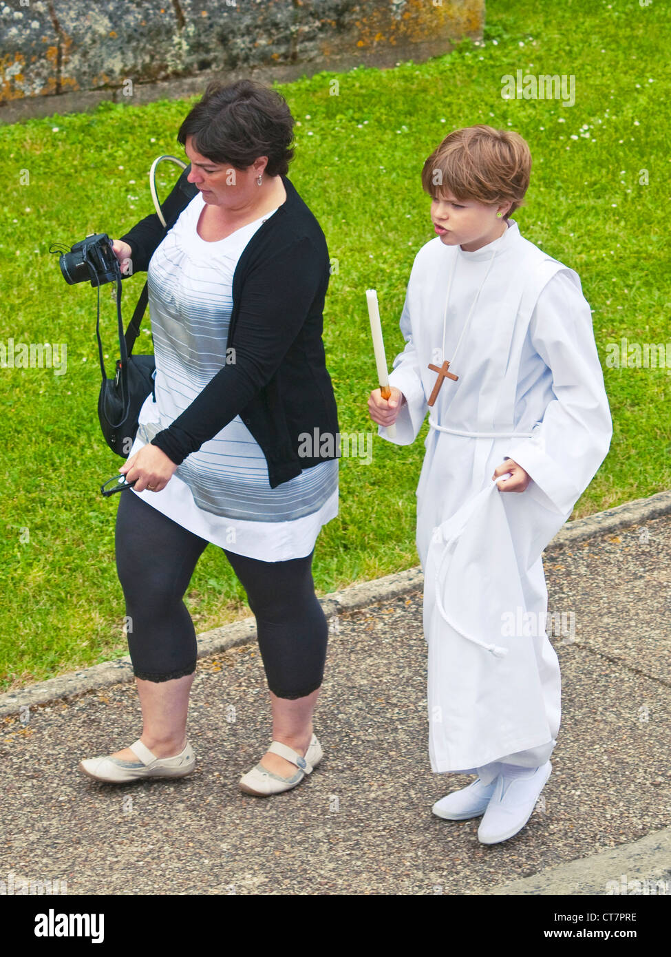 Madre con su hijo vestido para confirmación católica caminando sobre  pavimento - Francia Fotografía de stock - Alamy