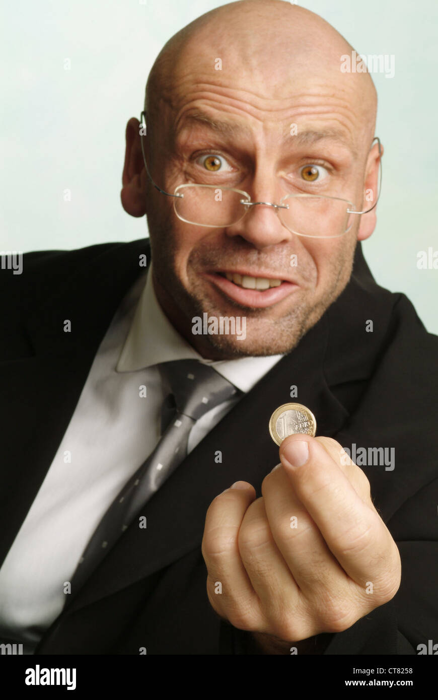 Hombre con 1 euro pedazo en la mano Foto de stock