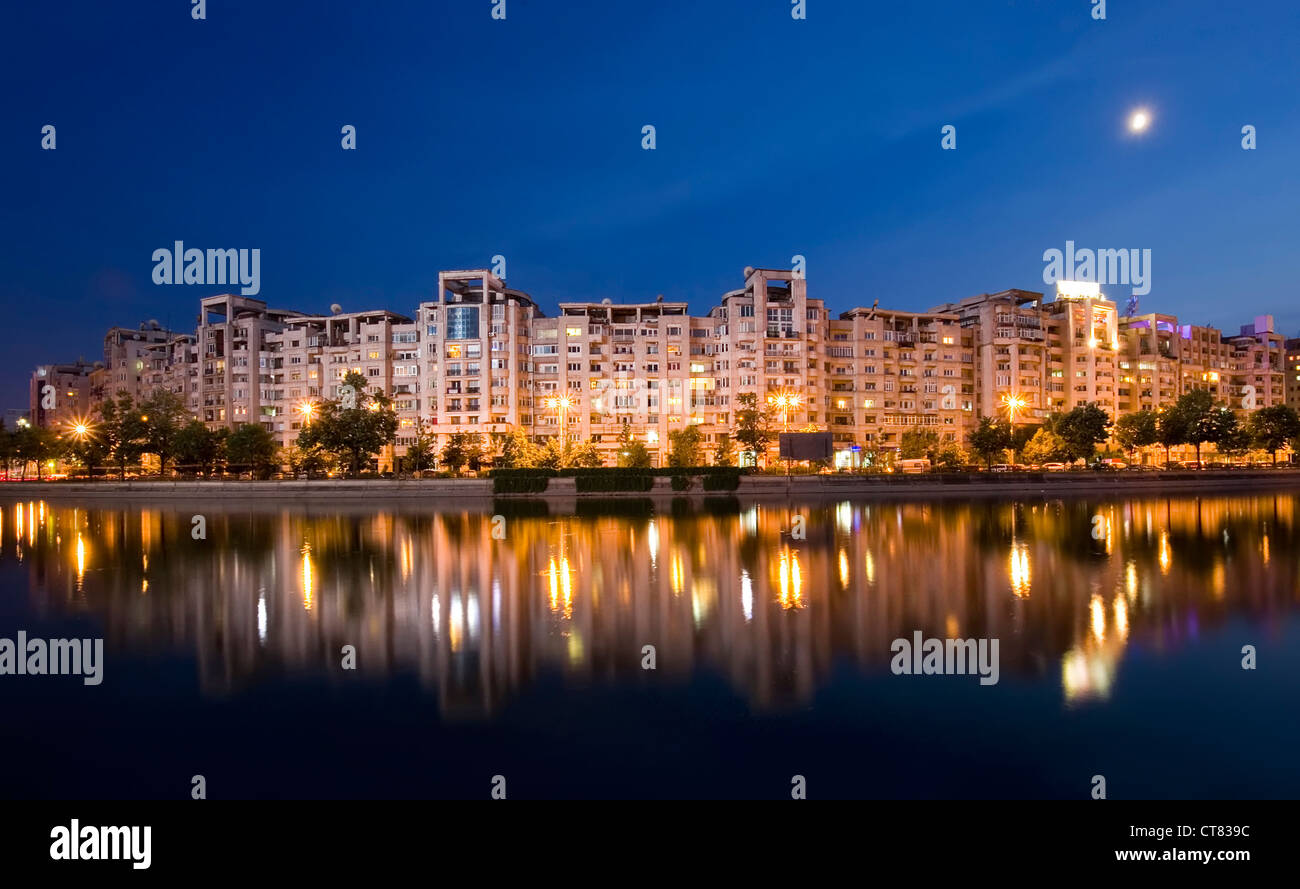 Río Dambovita y los edificios se reflejan en el agua, Bucarest, Rumanía escena nocturna. Foto de stock