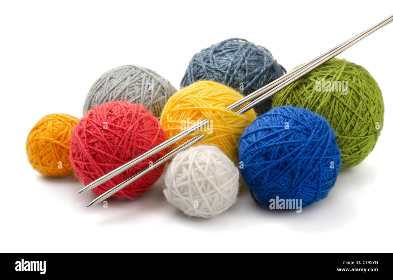 Hilo de color bolas y agujas de tejer aislado en blanco Foto de stock