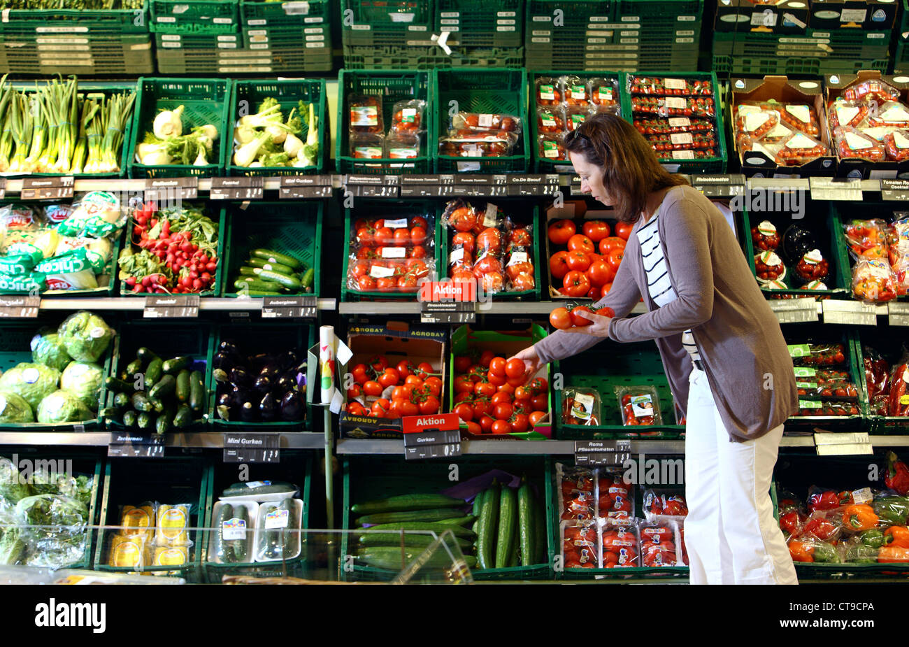 La mujer está de compras en un supermercado grande. Departamento de frutas y verduras. Foto de stock