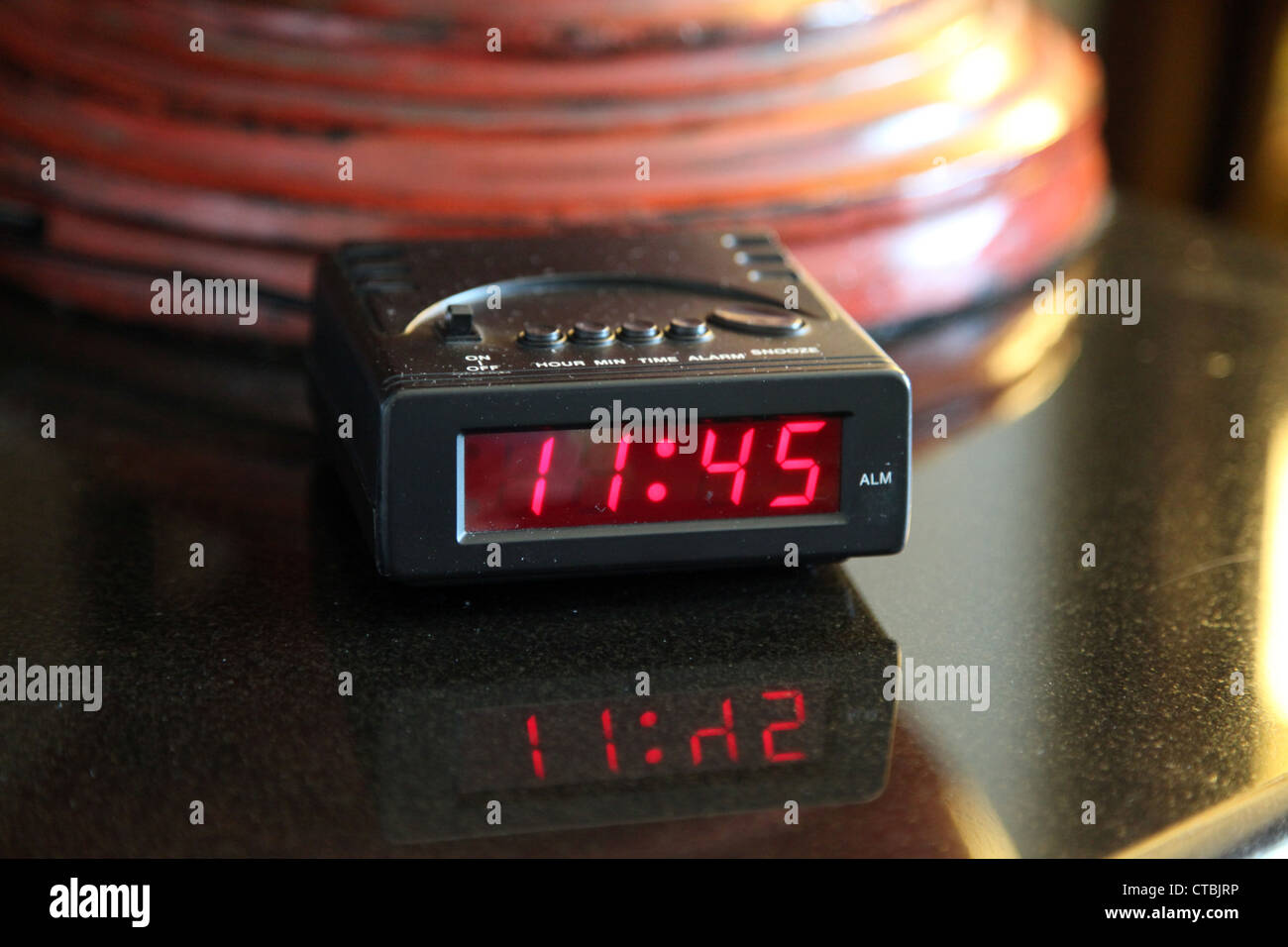 Es una foto de un dispositivo de alarma que dice 11.45 am o pm. Es en el  dormitorio cerca de la lámpara de pie Fotografía de stock - Alamy