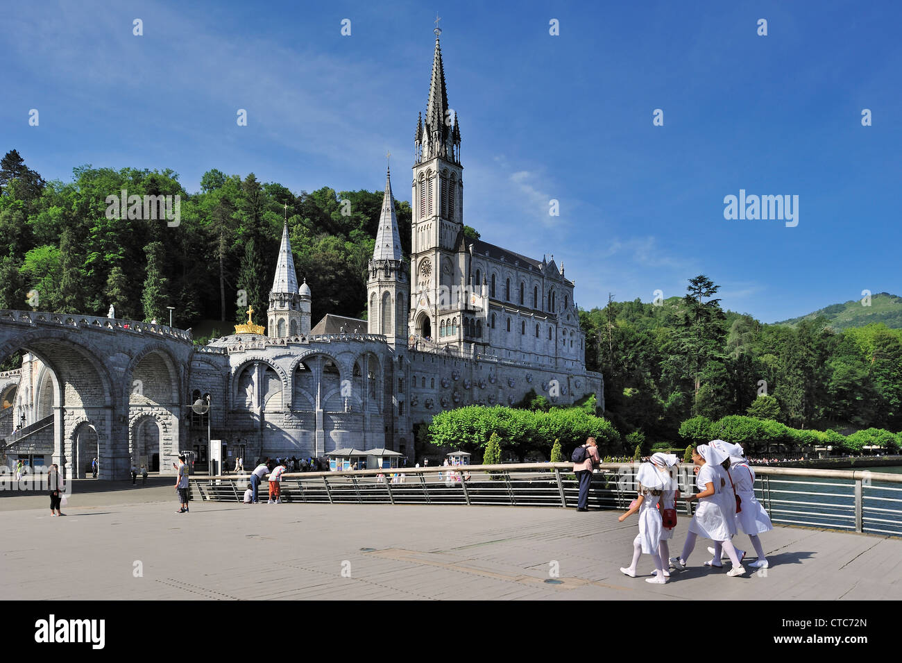 Enfermeras jóvenes delante de la Basílica de Nuestra Señora del Rosario en el Santuario de Nuestra de Lourdes, Pirineos, Francia Foto de stock
