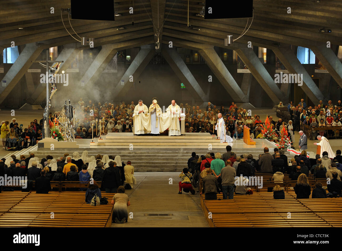 Servicio de iglesia en la Basílica de San Pío X / Basílica subterránea en el Santuario de Nuestra Señora de Lourdes, Pirineos, Francia Foto de stock