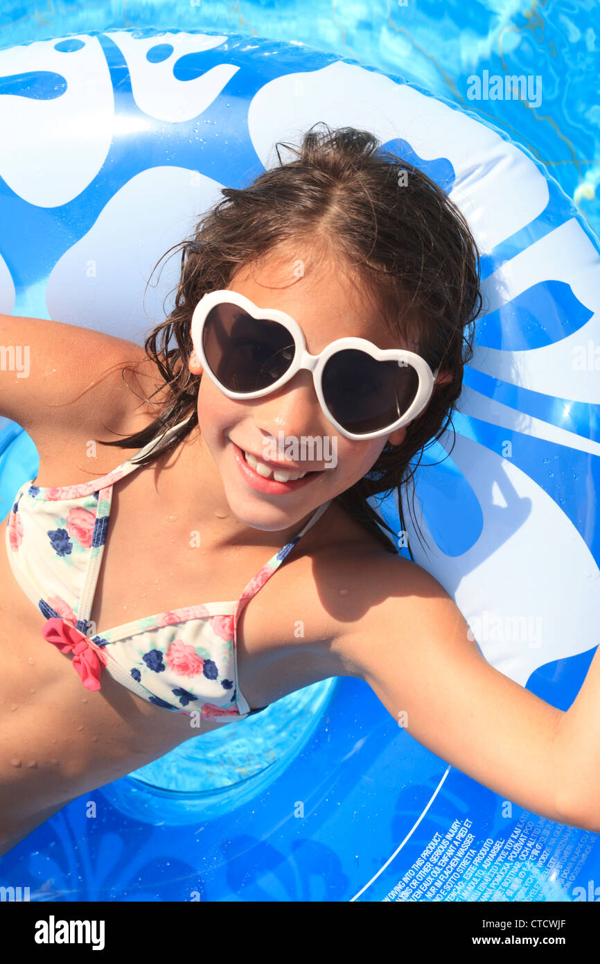 Niña (9-11 años) con gafas de sol en una piscina Fotografía de stock - Alamy