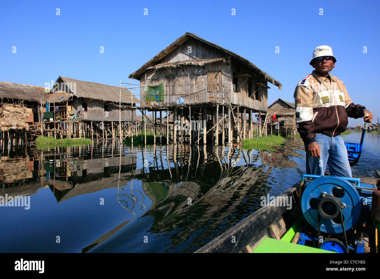 Barquero birmano conduciendo a través de pueblo flotante del lago Inle, el estado de Shan, en Myanmar, en el sudeste de Asia Foto de stock