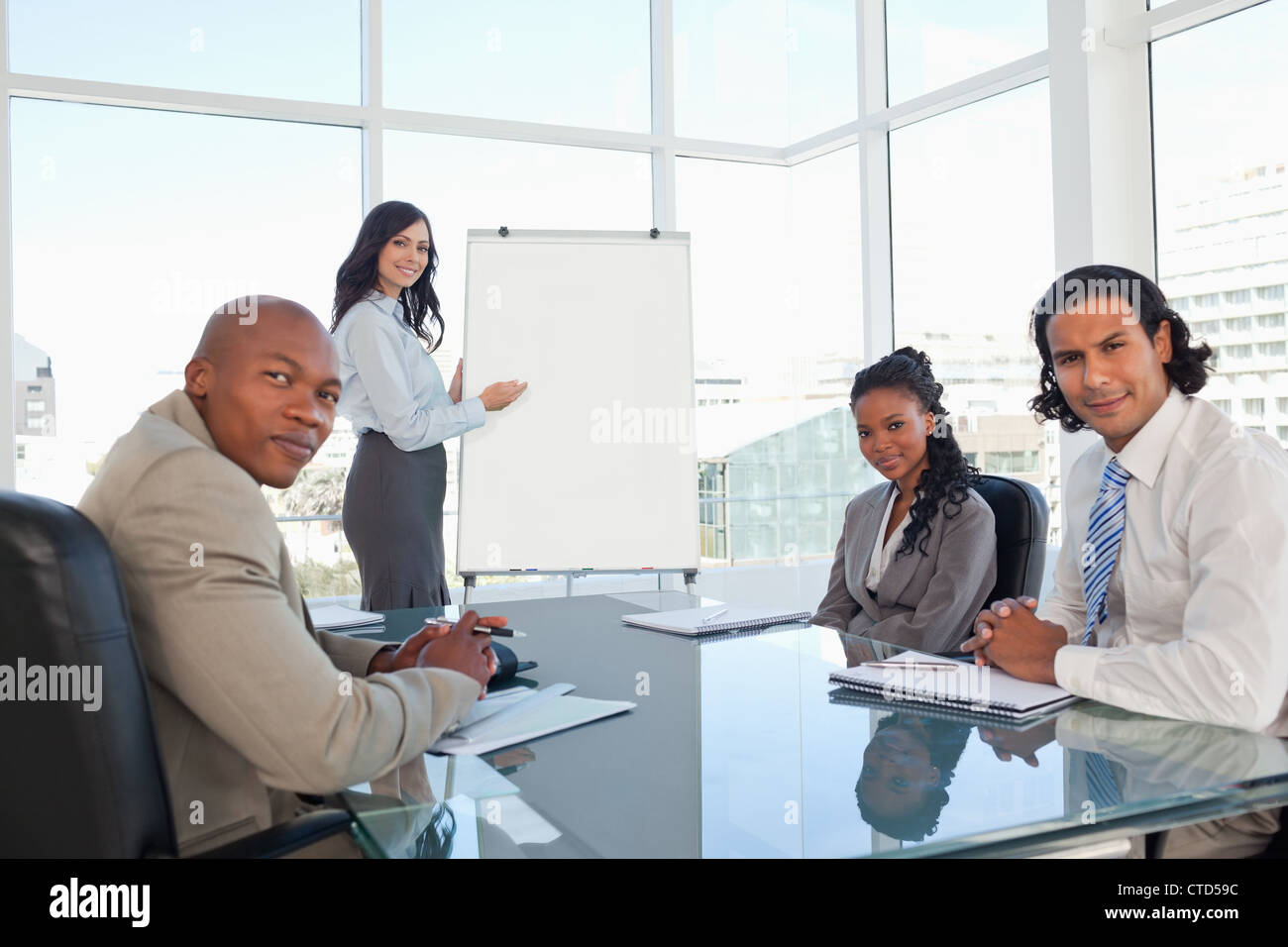 Equipo empresarial casi sonriente en una sala durante una presentación Foto de stock