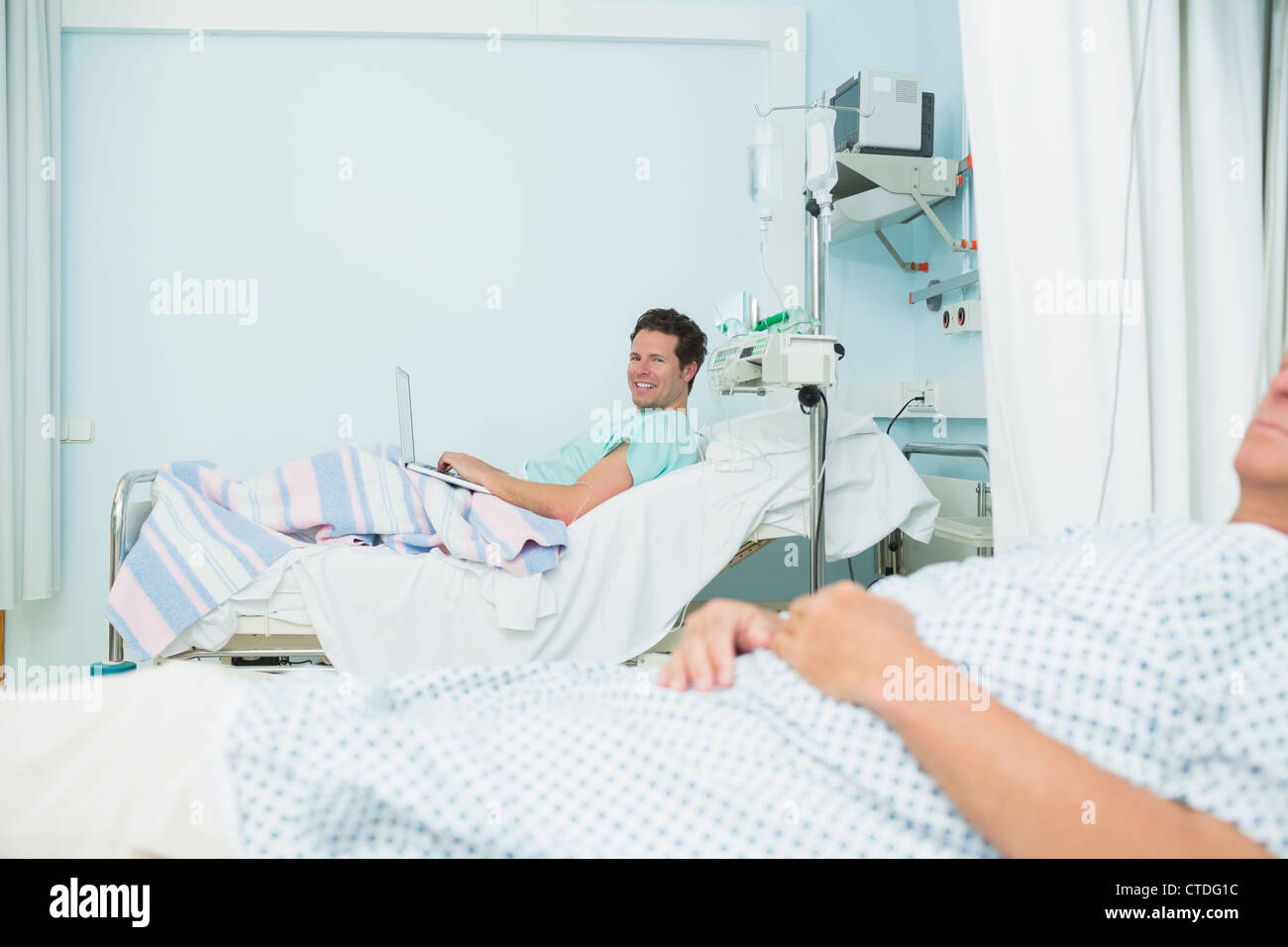 Los pacientes masculinos acostado en camas de hospital Fotografía de