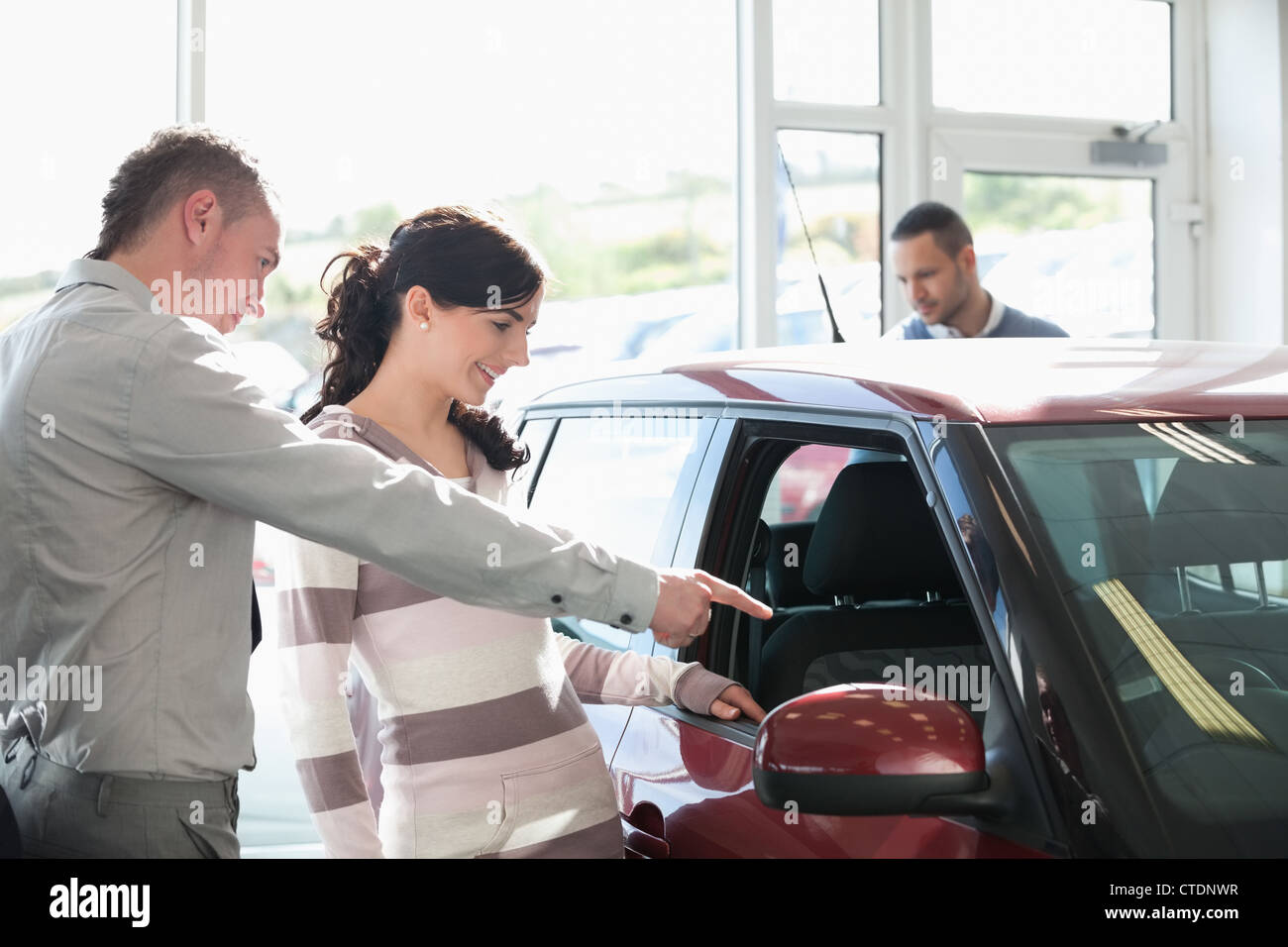 Concesionario de automóviles hacia el interior de un coche con una mujer Foto de stock