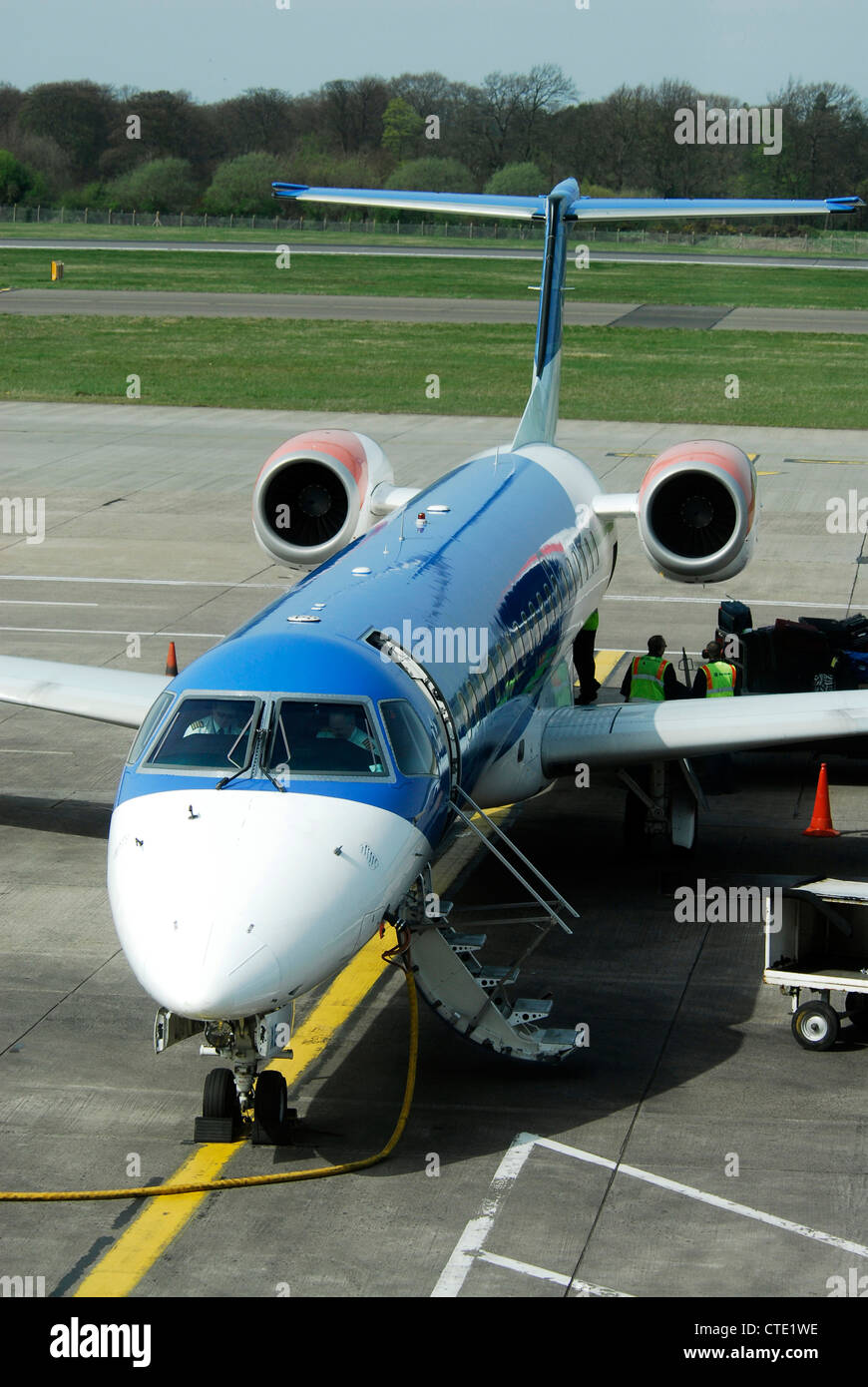 BMI Regional Embraer ERJ-145EP de descarga de carga de equipaje en el delantal en el aeropuerto de Edimburgo Foto de stock
