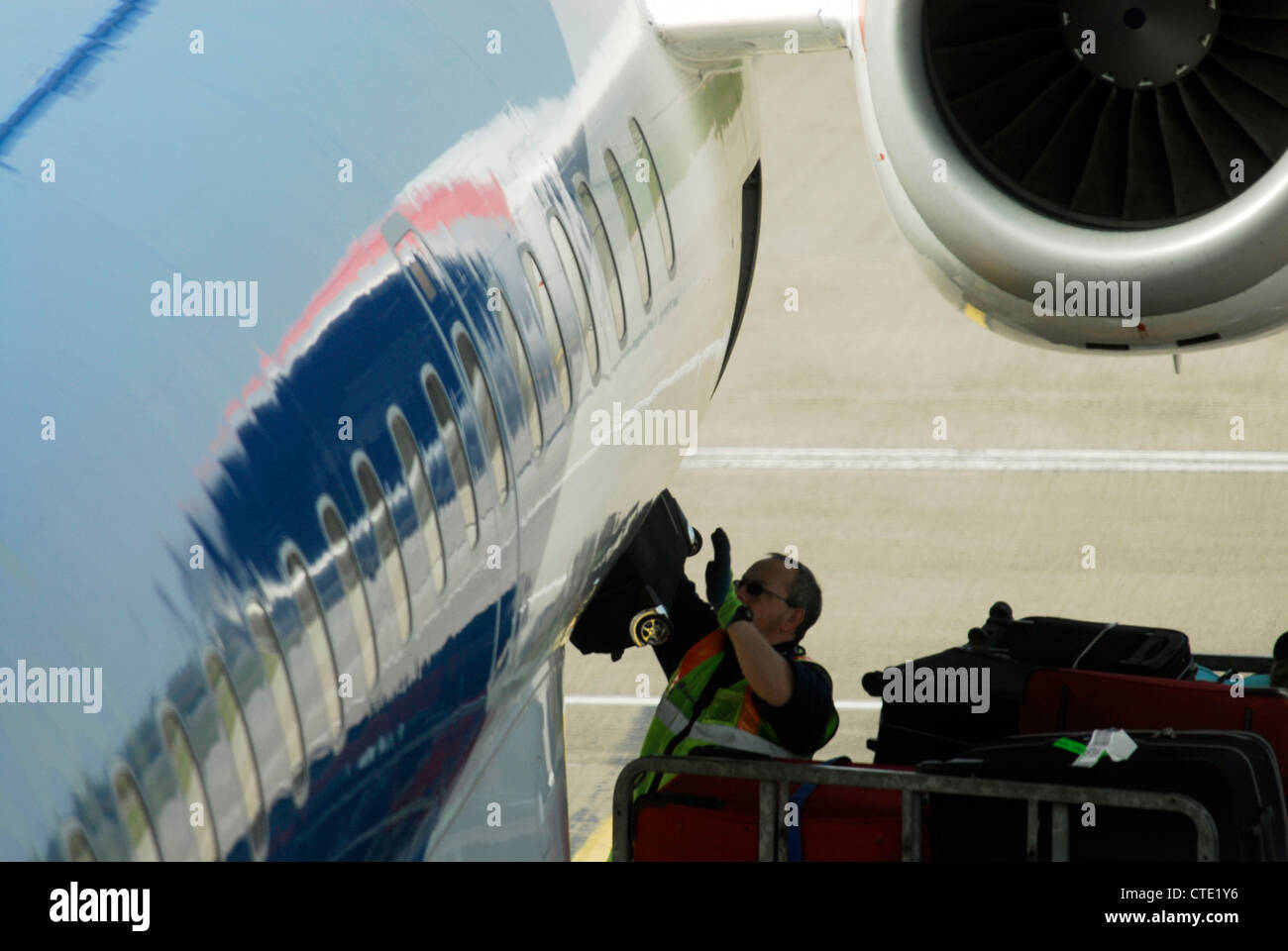Un equipaje Handler carga descarga bolsas maletas de equipaje a partir de  un avión en el aeropuerto de Edimburgo Fotografía de stock - Alamy