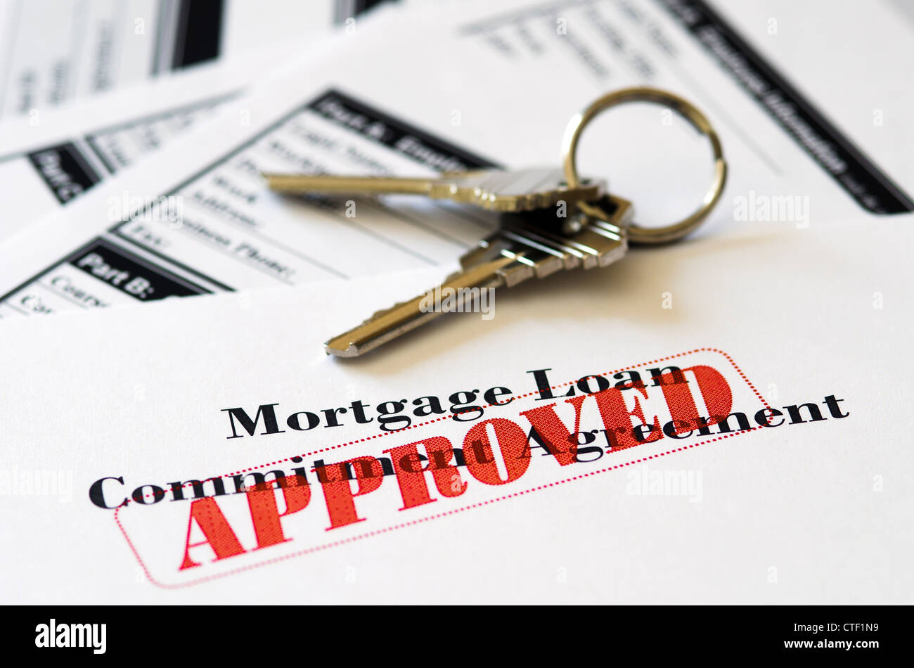 Hipotecas inmobiliarias préstamo aprobado el documento con llaves de casa Foto de stock