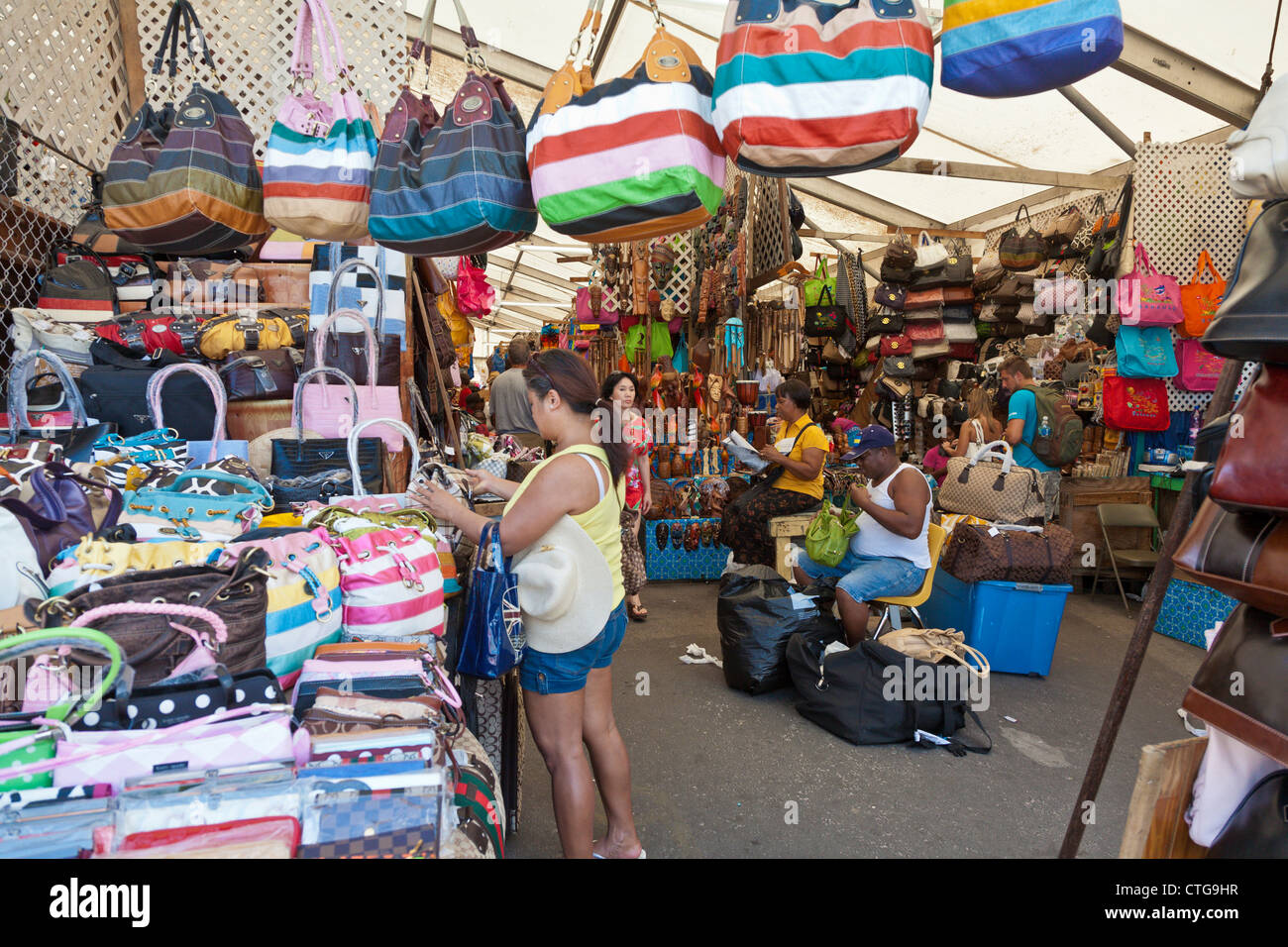 Hombres y mujeres turistas shop en el concurrido mercado de paja para regalos y souvenirs en Nassau, Las Bahamas Foto de stock