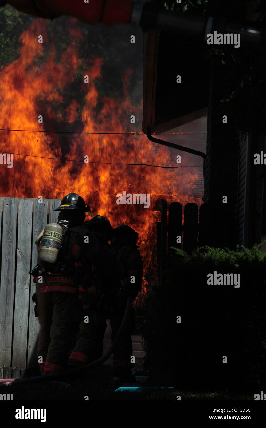 Los bomberos llegan al lugar del incendio de un garaje para encontrarla plenamente implicados. Foto de stock