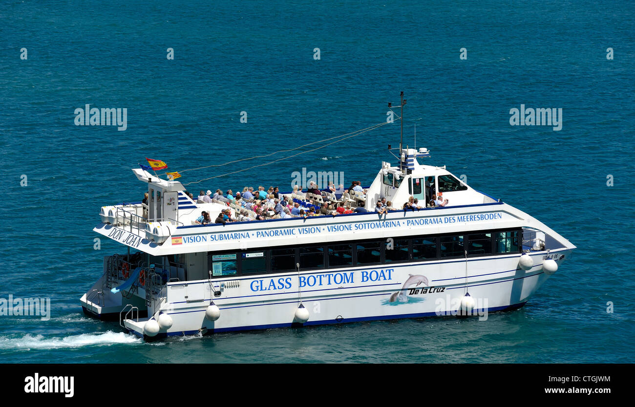 Don Joan catamarán barco con fondo de cristal dejando mahon por un viaje de vuelta al puerto menorca islas baleares españa Foto de stock