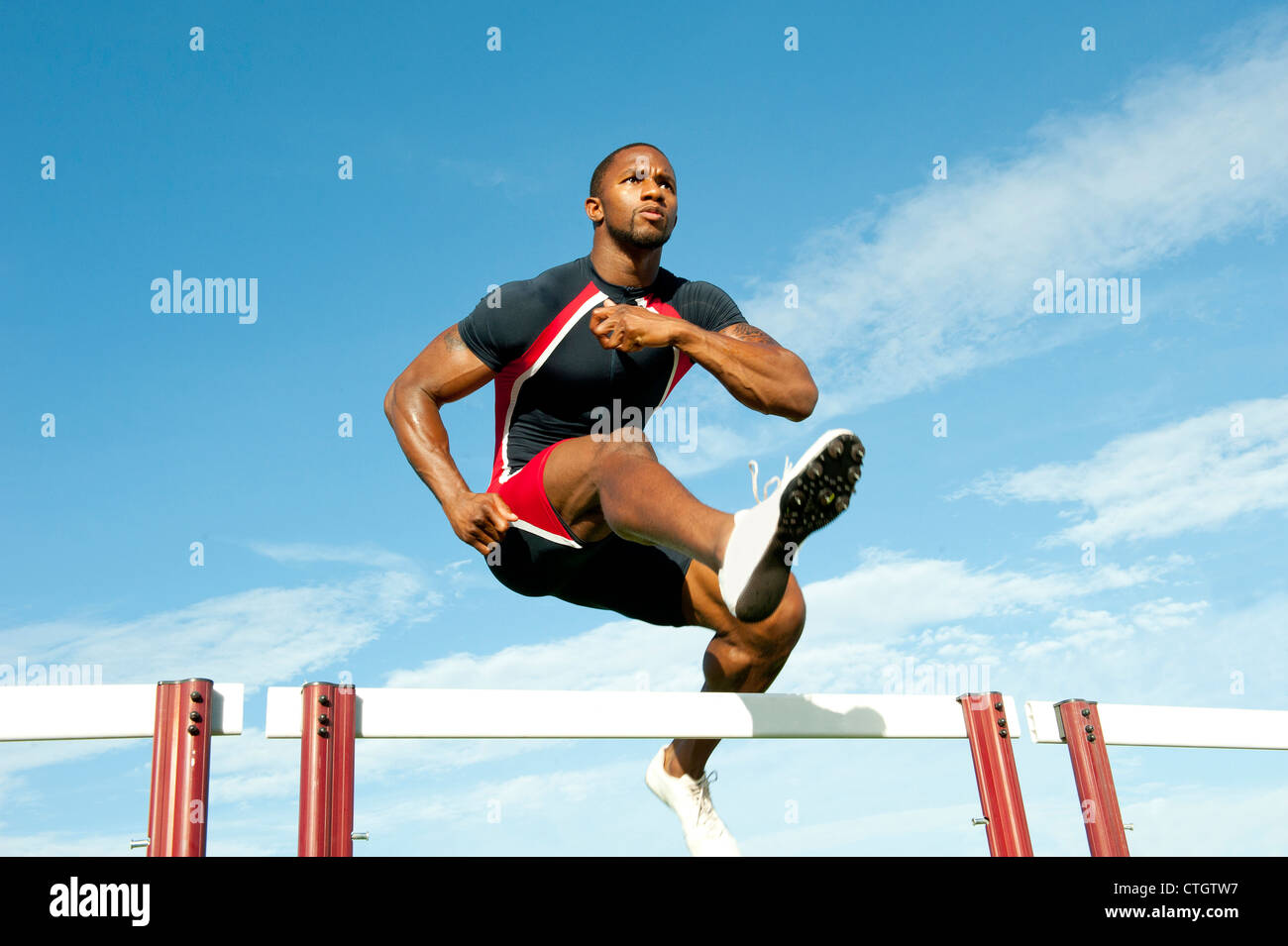 Black Runner saltar vallas en carrera Fotografía de stock - Alamy