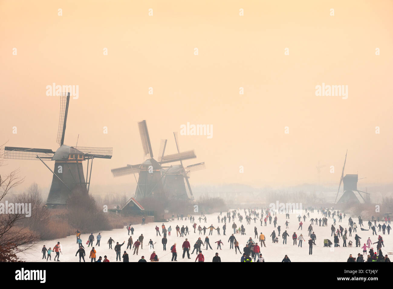 Los patinadores sobre hielo en holandés frente a cinco de los 19 molinos de Kinderdijk en el polder Alblasserwaard, Holanda, los Países Bajos. Foto de stock