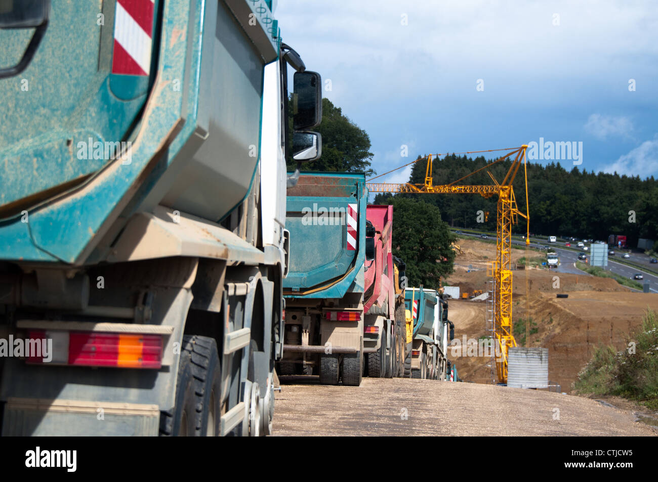 Fila de dum camiones están estacionados en un sitio de construcción de carreteras en Alemania Foto de stock