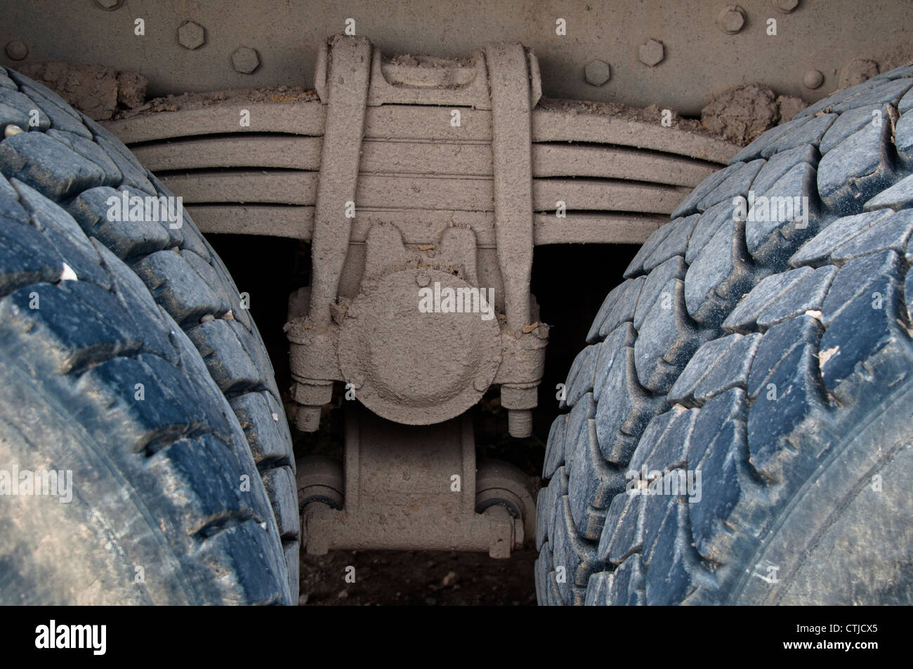 Detalle de la suspensión de ballesta con neumáticos de camión pesado sucio Foto de stock