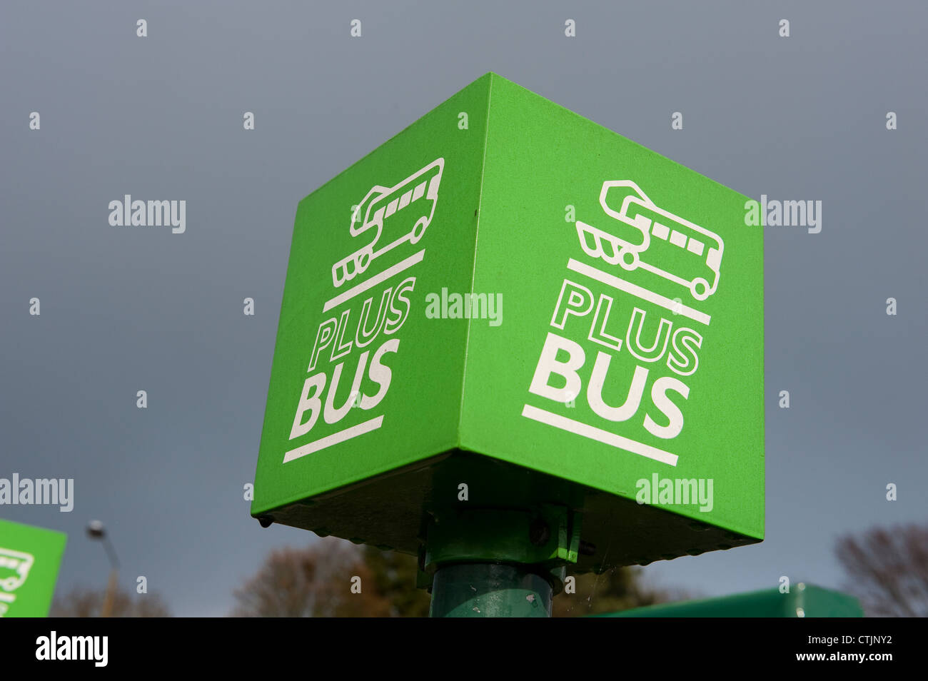 Plusbus firmar en una parada de autobús fuera de una estación de tren en Inglaterra. Foto de stock