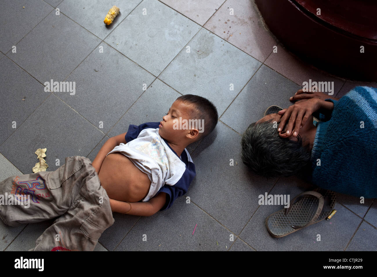 Un joven muchacho birmano duerme en uno de los pasillos que conducen a la Pagoda de Shwedagon, en Yangon (Rangún), Myanmar (Birmania) Foto de stock