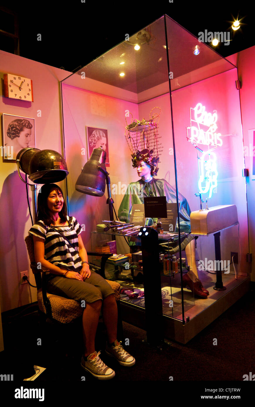 Joven Mujer Asiática sentado en una silla debajo de la pantalla secador museo de Vancouver Foto de stock