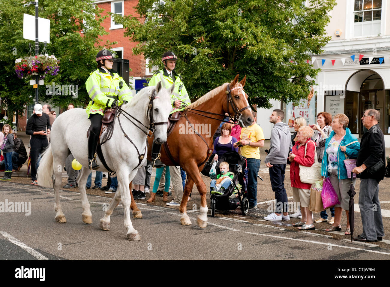 Dos policías montados en caballos de la policía patrulla las multitudes en Newmarket Suffolk UK Foto de stock
