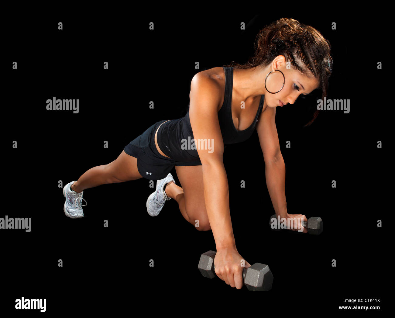 Ejercicio fitness bailarina pulse arriba haciendo ejercicio con pesas modelo deportivo contra el fondo negro iluminación de estudio. Foto de stock