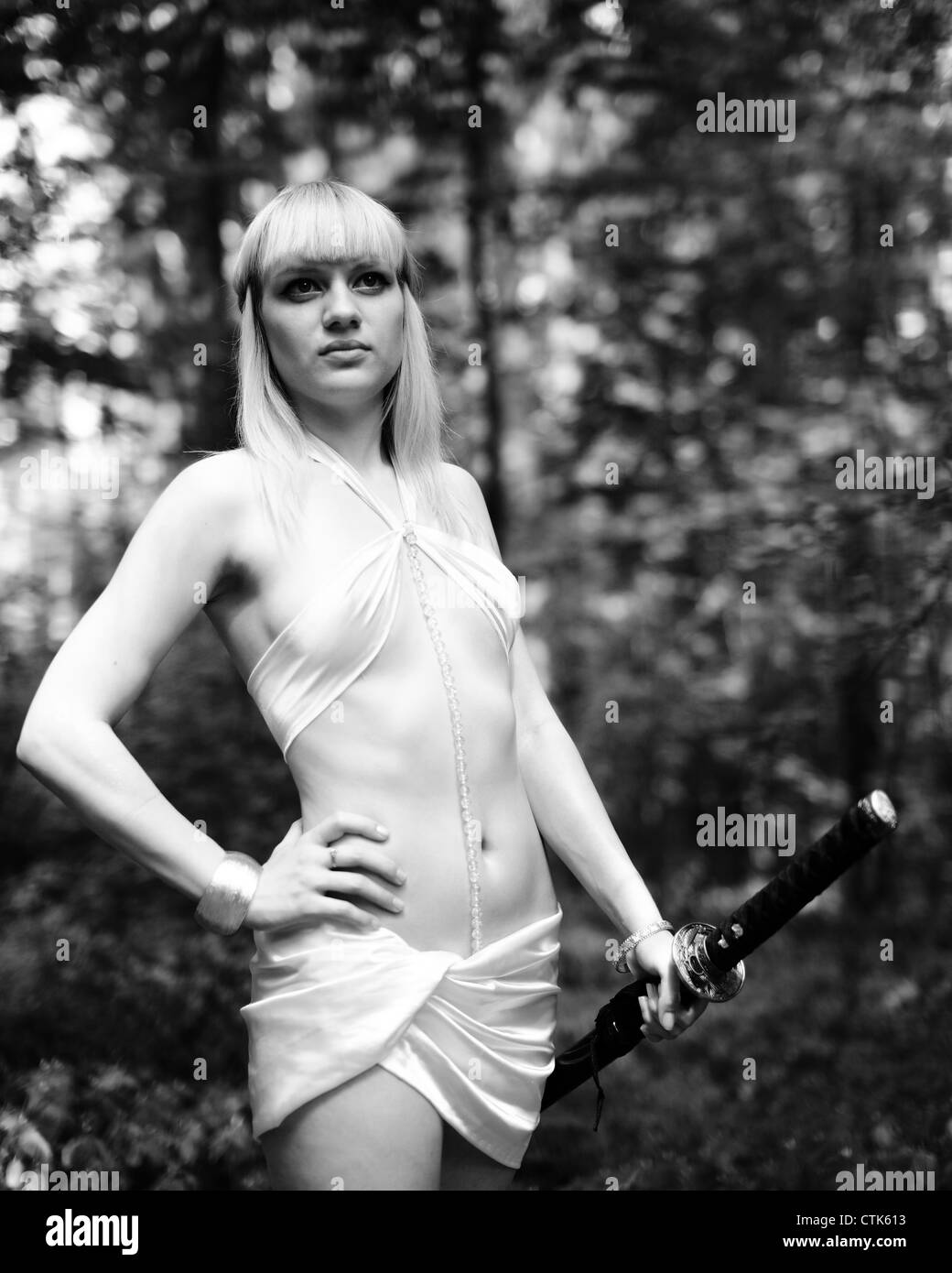 Fantasy mujer rubia con la espada en el bosque Foto de stock