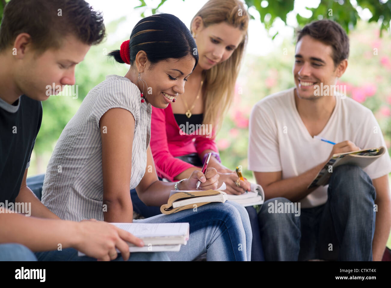 Los amigos y la educación, grupo de estudiantes universitarios, revisando los deberes y preparar la prueba Foto de stock